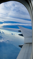 An airline wing cruising through thick  cloudy sky