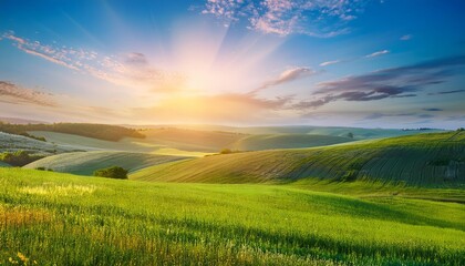Fototapeta premium panorama of rolling green hills bathed in the golden light of sunrise