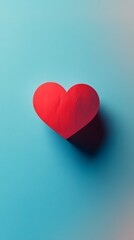 Obraz premium Red heart shape on a vibrant blue background conveying love and affection.
