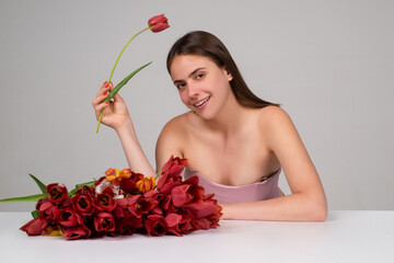 Beauty girl with tulip. Beautiful sensual woman hold bouquet of tulips, studio portrait.