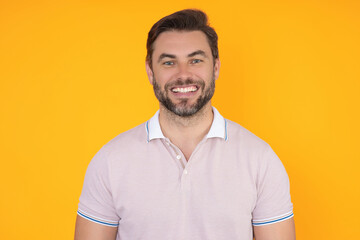 Obraz premium Studio portrait of Smiling male model isolated on yellow. Positive man in good mood. Friendly and smiling man. Handsome man looking at the camera. Positive person. Portrait of laughing man.