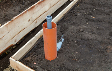 A pipe is sticking out of the ground in a dirt area