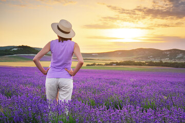 Woman in meadow of lavender at sunset