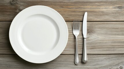 Simple Table Setting with White Plate and Silverware on Rustic Wooden Background