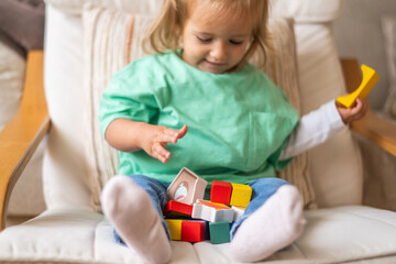 Curious Baby Playing With Safe, Educational Wooden Blocks And Smiling Happily. Emotions And Natural Expressions