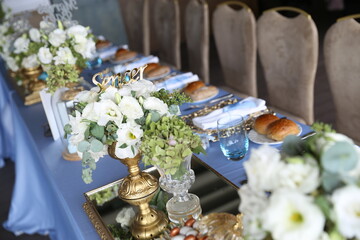 Elegant Long Table Setting with Blue Tablecloth and Gold Accents