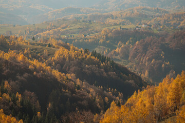 Fototapeta premium Scenic autumn overview of Magura village in Romania, near the Piatra Craiului mountains