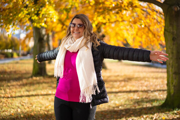 Beautiful happy young woman wearing black trousers, dark jacket, pink sweater, light scarf, glasses...