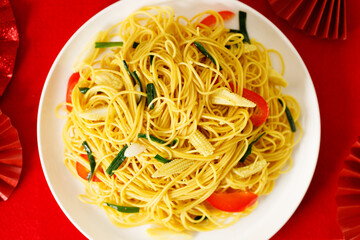 Chinese Lunar New Year concept with lucky food longevity noodles on wooden table background.