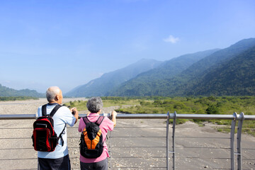 Travel and tourism. Senior family couple walking together on bridge