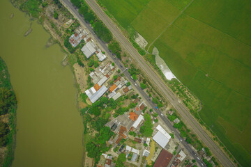 An aerial view showcasing riverside development with agricultural fields and housing adjacent to...