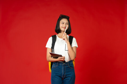 The studio photoshoot captures an Asian teenage school girl deeply focused on her studies, emphasizing her dedication to education and the limitless knowledge she seeks to acquire.