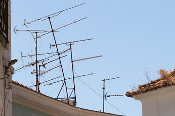 Multiple and messy analog terrestrial directional television antennas on a rooftop in Lisbon, Portugal