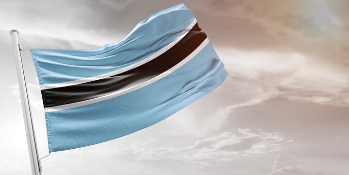 Botswana national flag cloth fabric waving on beautiful grey Background.
