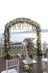 Romantic outdoor wedding ceremony with a floral arch and city skyline view