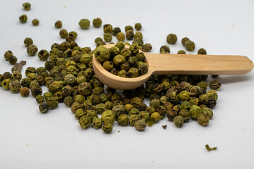 green peppercorn and wooden spoon
