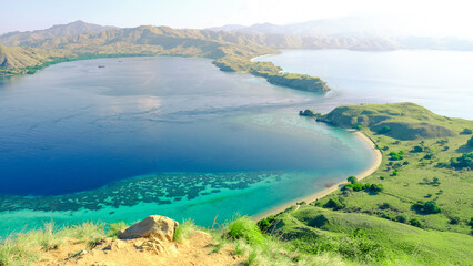 Beautiful coastal landscape at Gili Lawa, Komodo National Park, Indonesia. Beautiful green landscape with white clouds and blue sea in background. © Balnyes Visuals