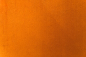 Oriole or orange paint on cement wall texture as background.
