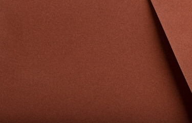 Fototapeta premium Designer paper background with a velvety, matte texture in warm, earthy hues like terracotta, ochre, and cinnamon. This rich, plush surface has a subtle gradient and grainy,