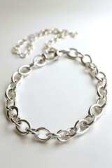 Silver chain bracelet lying on white background, intricate design with delicate links