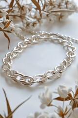 Obraz premium Silver chain bracelet lying on white background, intricate design with delicate links