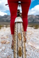 A close up of a person riding a bike on a dirt road