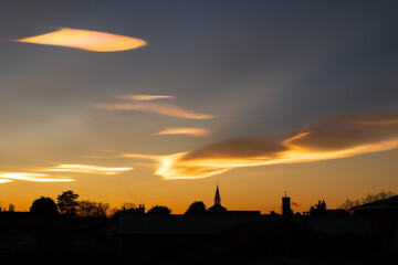 iridescent clouds during a beautiful winter sunset over the city.