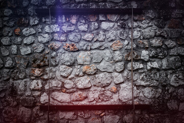 A textured stone wall with visible rustic elements, accented by faint lighting effects and a...