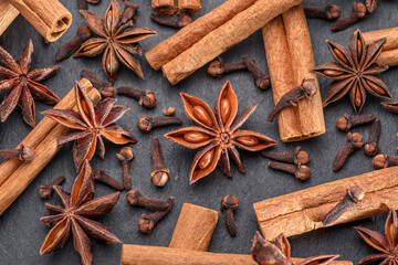 Lots of three spices for mulled wine – star anise, cinnamon and clove, macro.