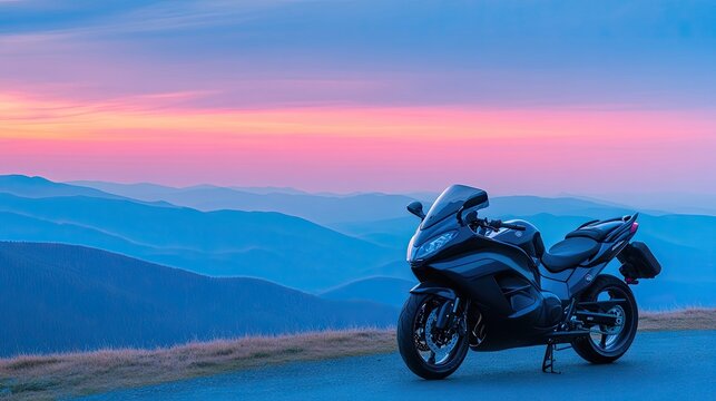 Black touring motorcycle perched at a scenic mountain overlook during a vibrant sunset in a rugged landscape