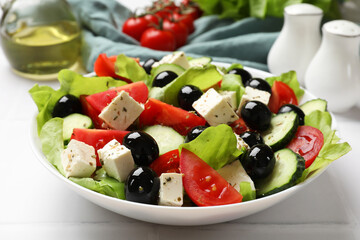 Delicious salad with feta cheese on white tiled table, closeup