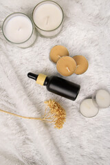 Matte Black Dropper Bottles on Wooden Plate with Natural Elements &ndash; Modern Skincare Packaging