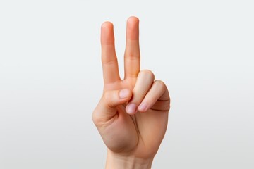 Naklejka premium Human Hand Giving a V Gesture, Peace Sign Hand Gesture, Victory Gesture Hand Sign Against a White Background