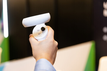 A virtual reality joystick in a person's hand, with a blurry background around.