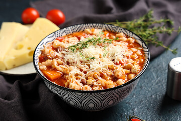 Fototapeta premium Bowl of pasta fagioli with cheese and thyme on dark background