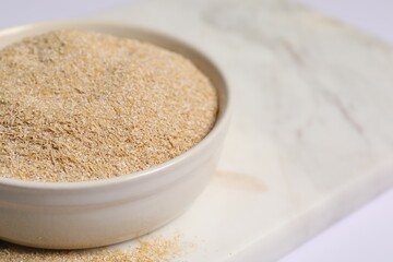 Oat bran in bowl on table, closeup. Space for text