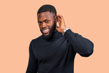 Curious businessman listening carefully with hand cupped to ear