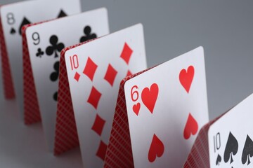Row of playing cards on grey background, closeup