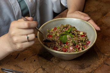 Tabbouleh salad in a bowl on a wooden table .quinoa salad