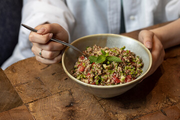 Tabbouleh salad in a bowl on a wooden table .quinoa salad