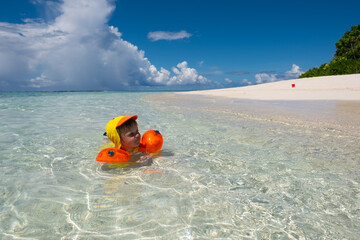 Obraz premium Toddler Relaxing in Warm Shallow Waters of a Local Maldivian Island