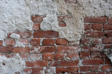 Red brick wall with remnants of cement, cement, mortar. Brutal construction background