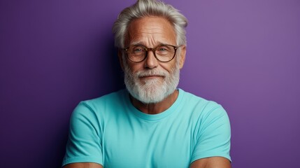 Obraz premium Portrait of a confident elderly man with gray hair and beard wearing glasses and a teal shirt, smiling against a vibrant purple background.
