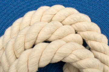 Detail of a twisted rope on blue background