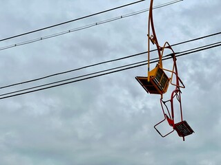 Unique urban cable chairlift over canal with colorful open-air gondolas in Palavas-les-Flots, France, showcasing the world's shortest chairlift amid coastal buildings and moored boats