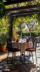 A romantic outdoor dining setup with a table amidst lush greenery.