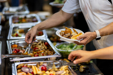 A diverse buffet spread with diners selecting food at a casual gathering during lunchtime