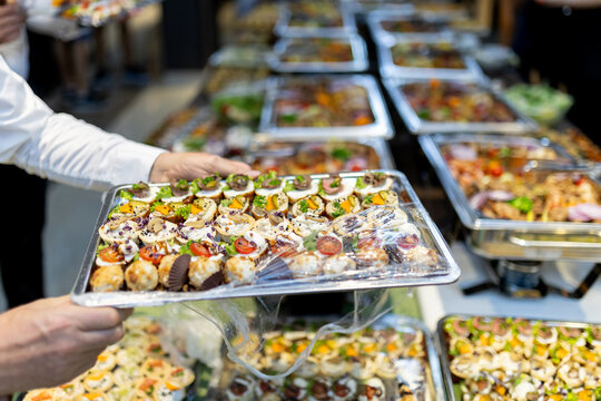 A catered tray of assorted appetizers prepared for a bustling event held in a spacious indoor venue