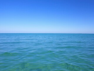 Obraz premium A serene ocean landscape with calm waters and a clear blue sky, reflecting the peaceful beauty of nature, landscape, beauty, waves