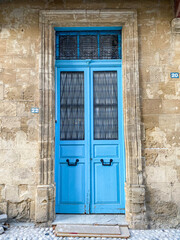 Blue wooden door located in a renovated street in the old settlement.